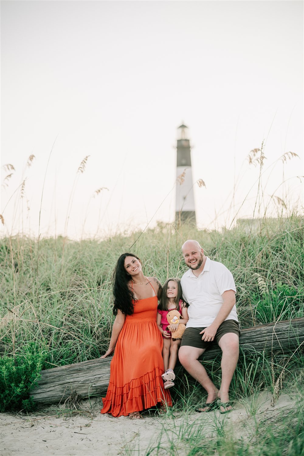 Jon Dabney with his wife and daughter at the beach near a lighthouse